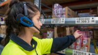 Worker using voice picking technology to pull product from shelves