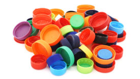 Colorful plastic caps pile isolated in white.